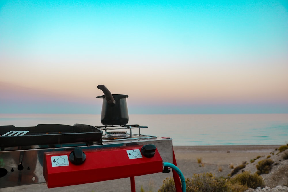 black and red gas grill on brown sand beach during daytime