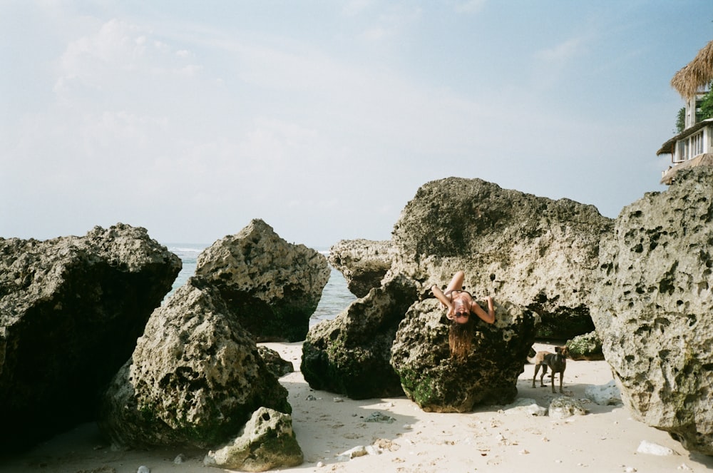 people walking on white sand beach near gray rock formation during daytime