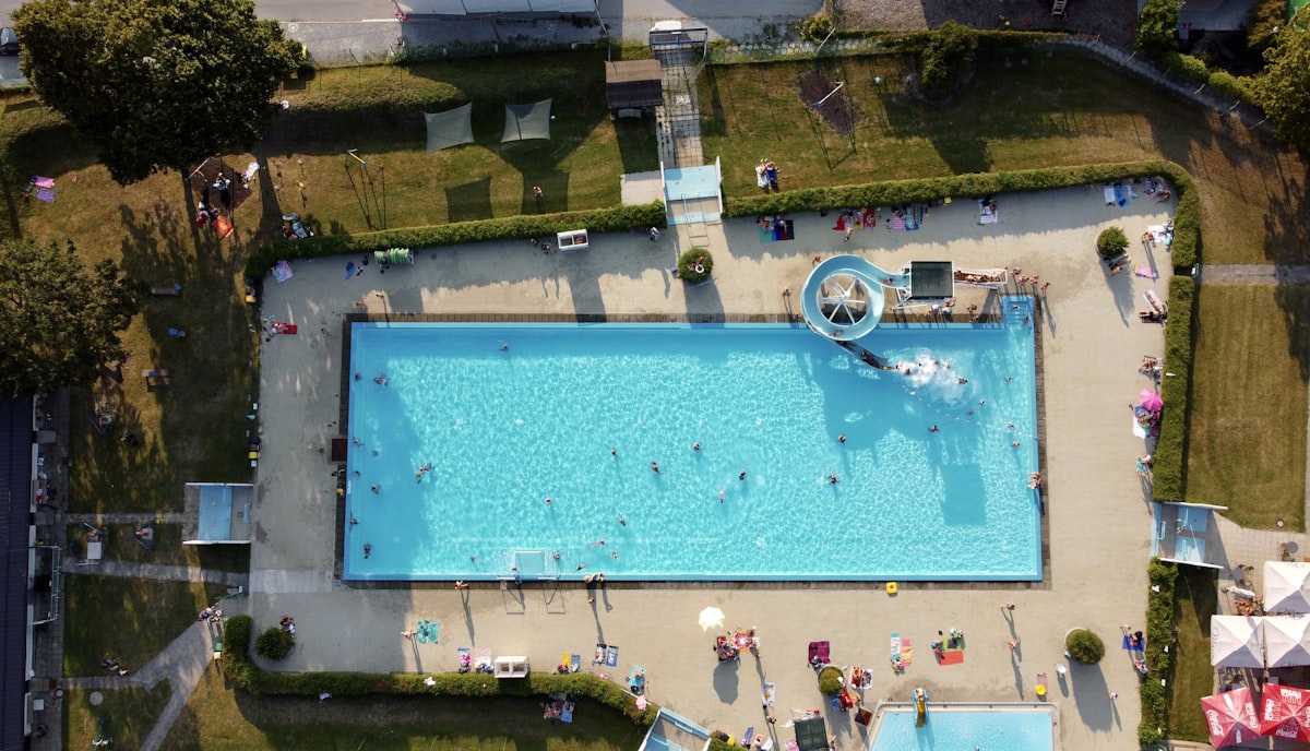 Aerial view of a large outdoor public swimming pool complex.