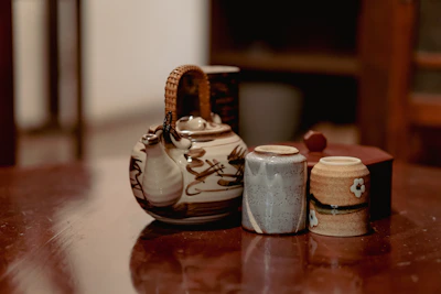 A cozy kitchen scene with a handmade ceramic teapot and matching cups on a rustic linen cloth.