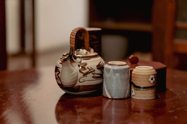 A hand-crafted clay teapot with lively patterns sitting on a rustic linen cloth, inviting slow moments.
