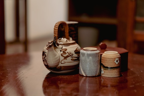 A close-up of a handcrafted ceramic tea set with warm, rustic textures and elegant shapes.