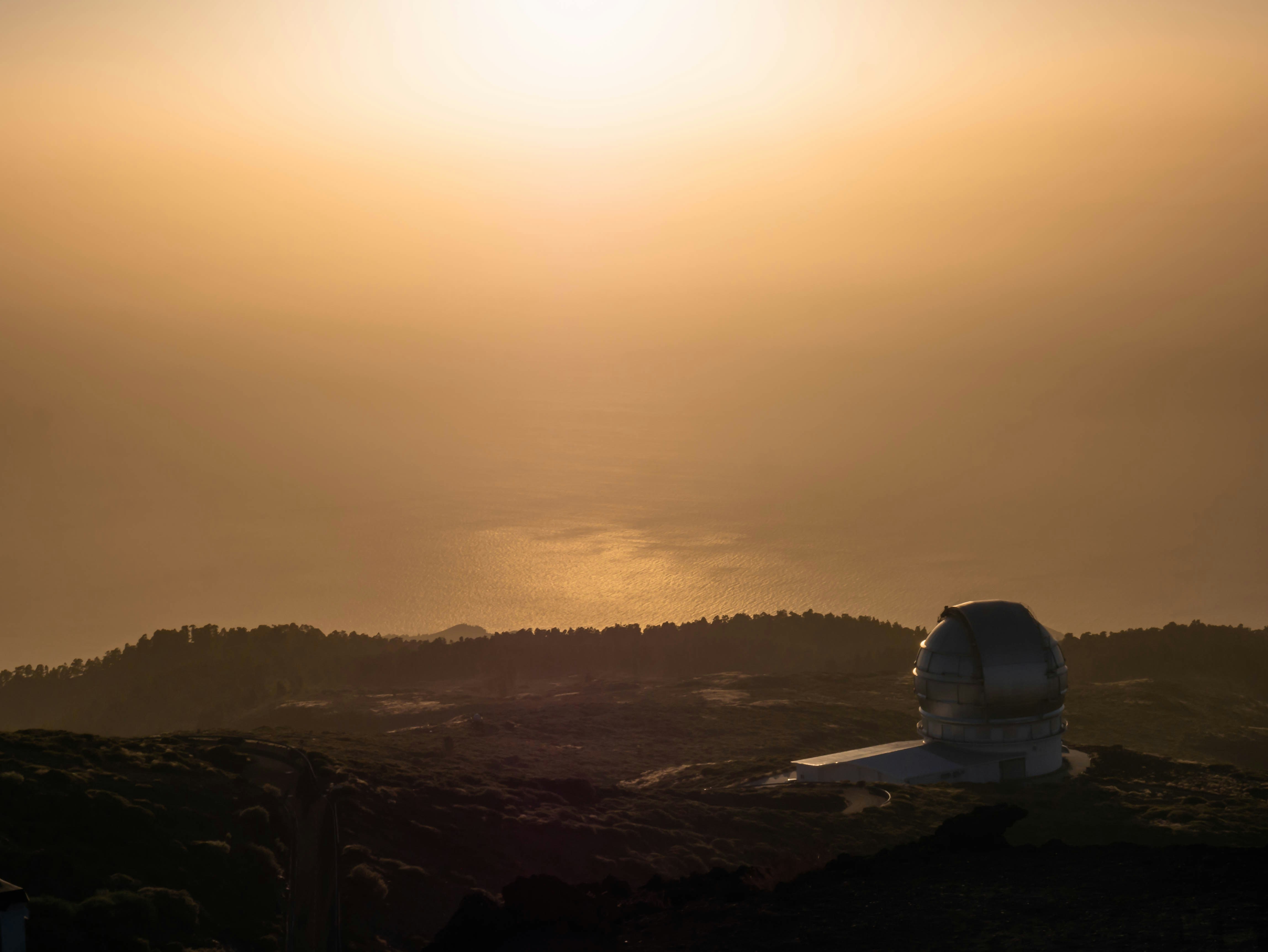 Minimalist hilltop observatory structure emerging from Japanese landscape with sea view at dawn