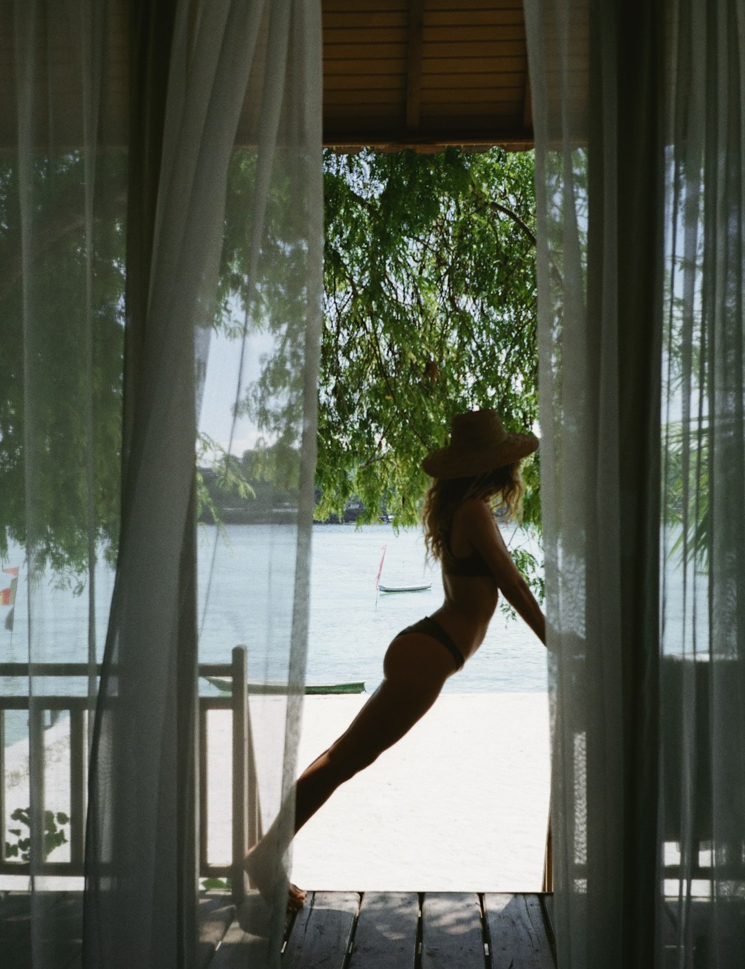 woman in black bikini standing near window