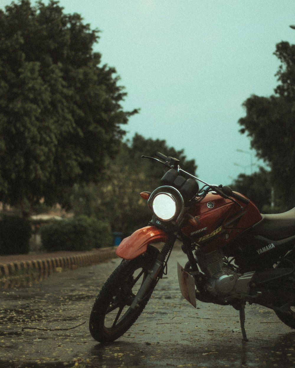 black and orange motorcycle parked on gray concrete road during daytime