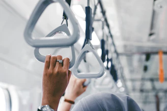 a person holding onto a metal object on a train