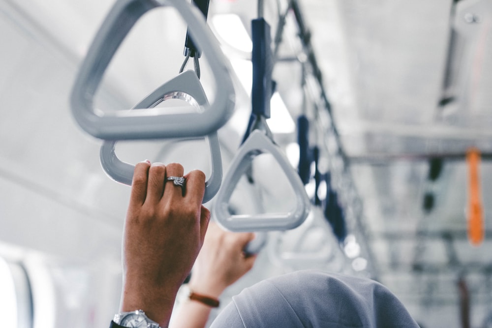 a person holding onto a metal object on a train