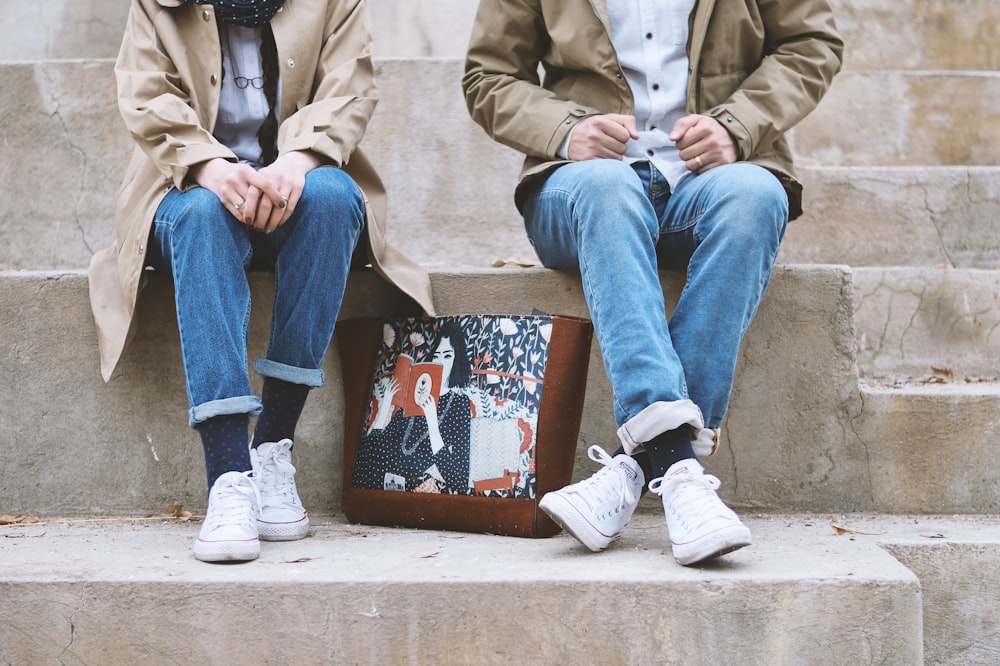 man in brown coat sitting on brown concrete bench