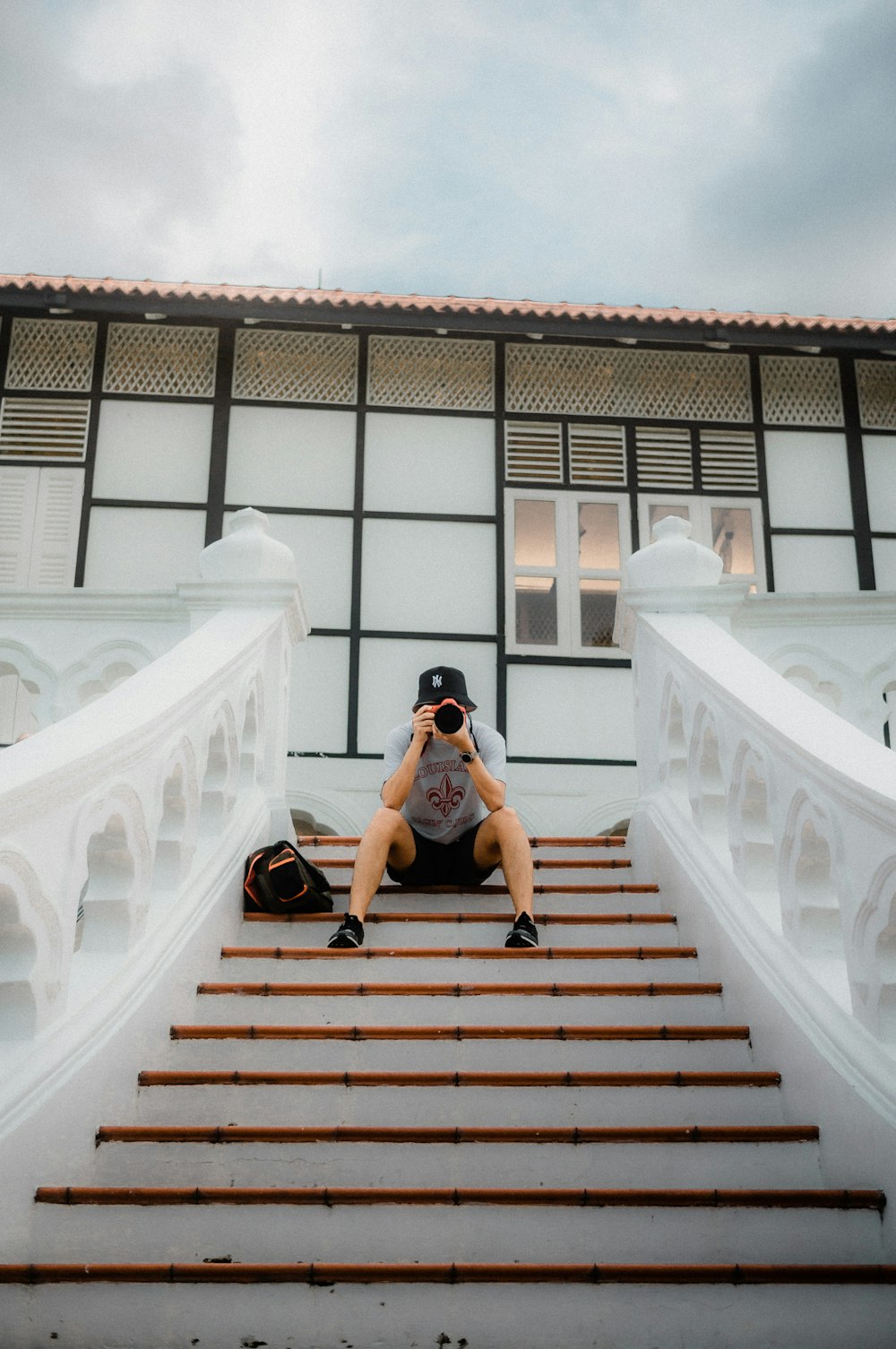 a person sitting on a set of stairs taking a picture