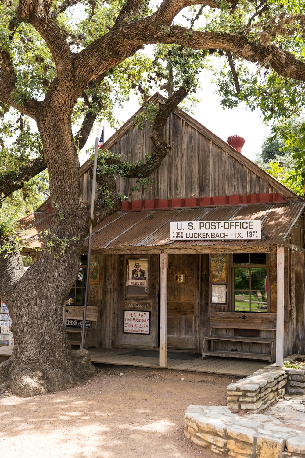 brown wooden building near green tree during daytime