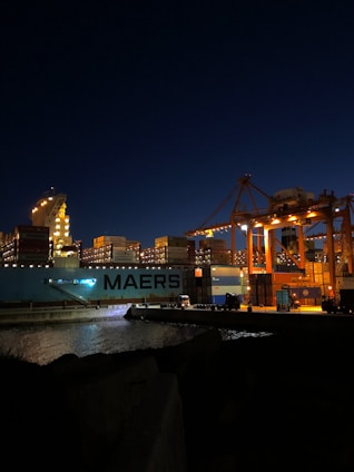 a large cargo ship in a harbor at night