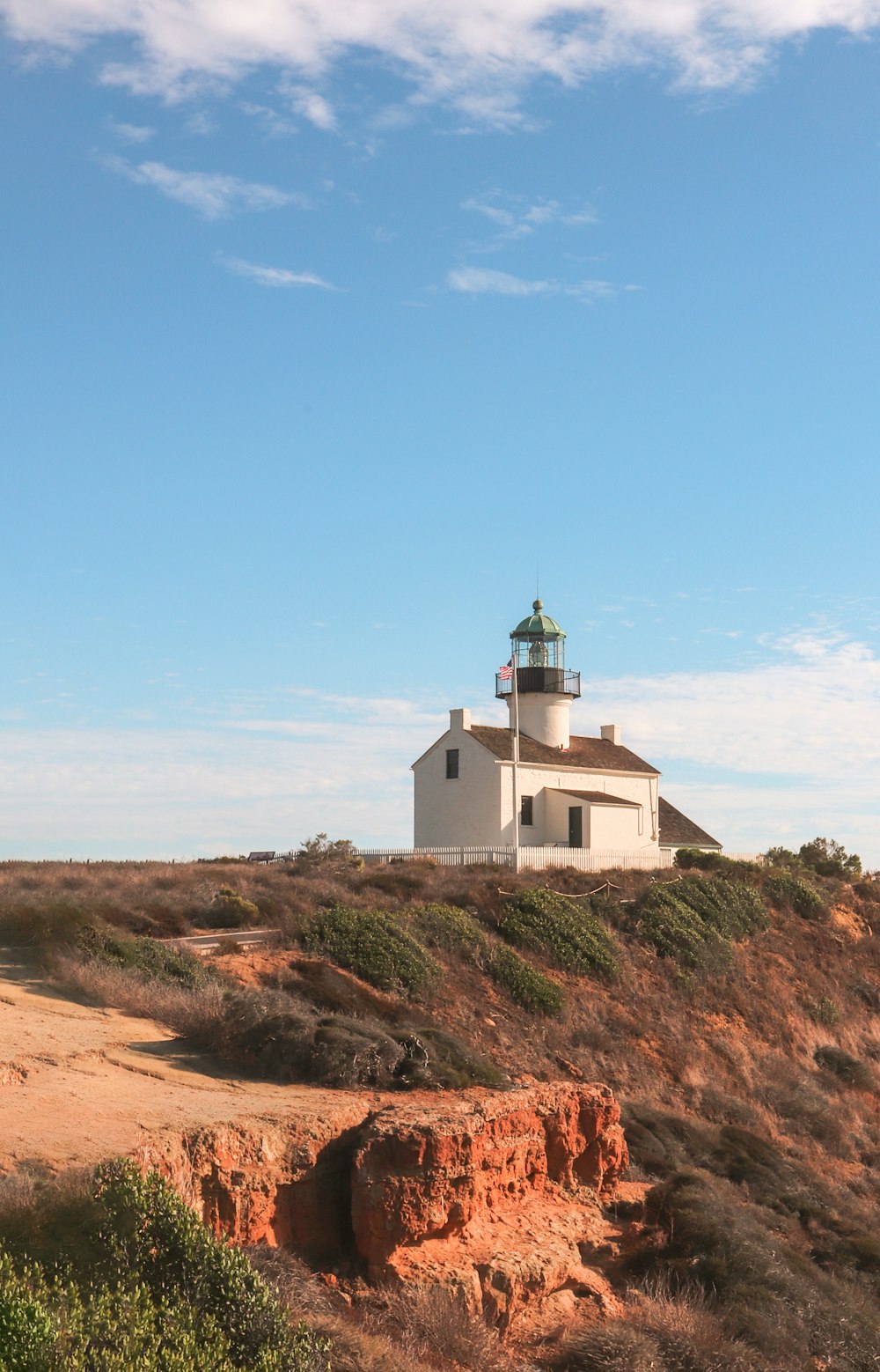 a lighthouse on top of a hill with a sky background