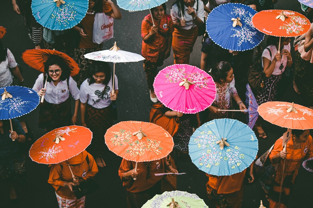 Eine Gruppe von Menschen, die umeinander stehen und Regenschirme halten