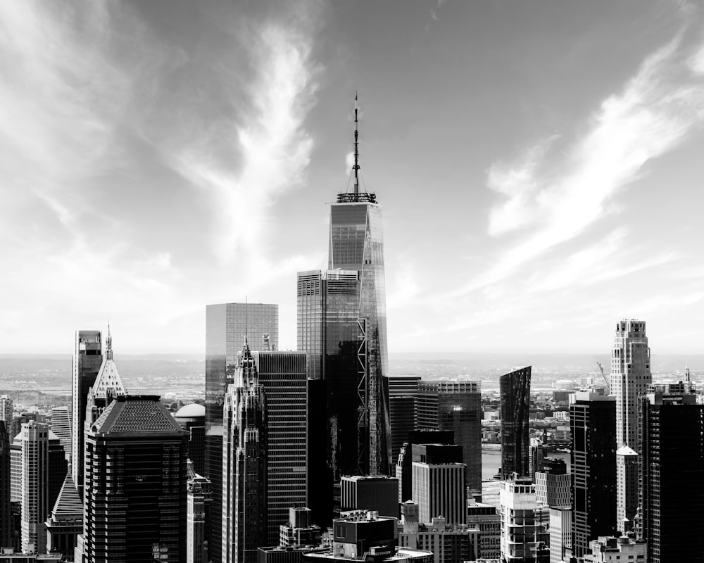 grayscale photo of city buildings under cloudy sky