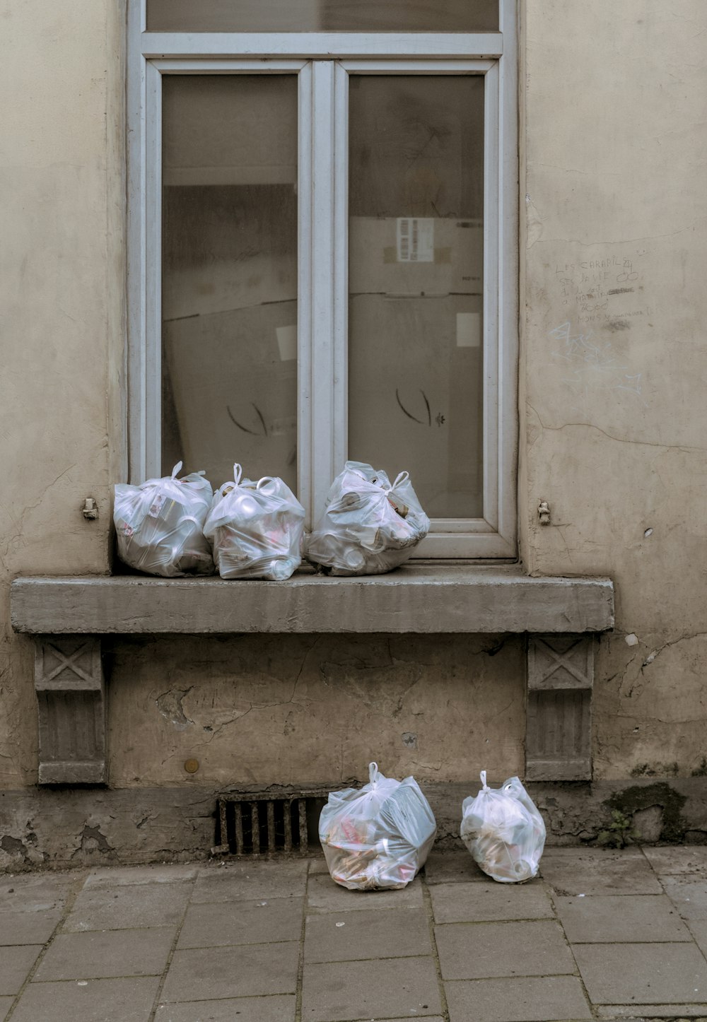 bags of garbage sitting on a window sill