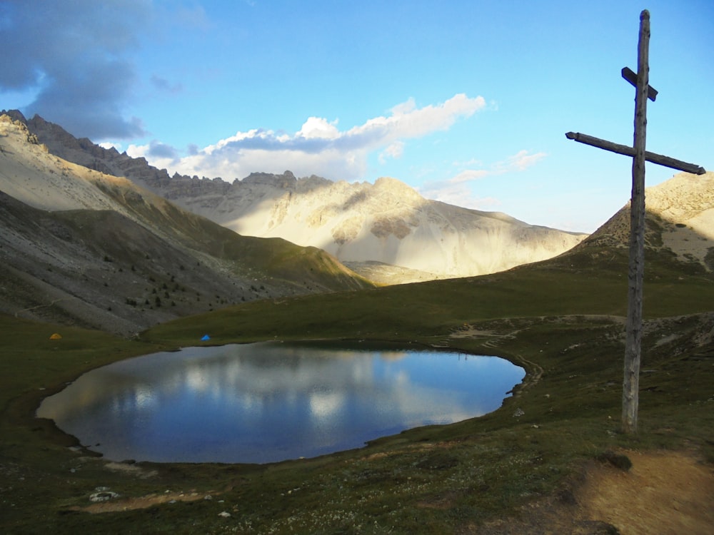 a cross on a hill with a lake in the foreground