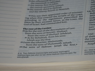 A close-up view of a page in a book, likely religious or historical in nature, detailing the descendants of Levi. The page includes numbered verses and footnotes at the bottom.