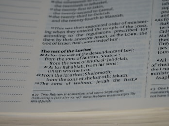 A close-up view of a page in a book, likely religious or historical in nature, detailing the descendants of Levi. The page includes numbered verses and footnotes at the bottom.