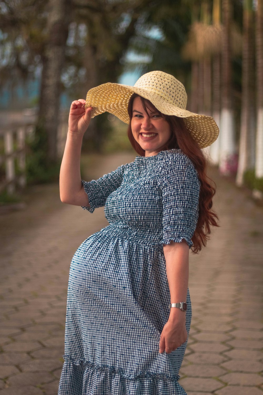 a woman in a blue dress and a straw hat