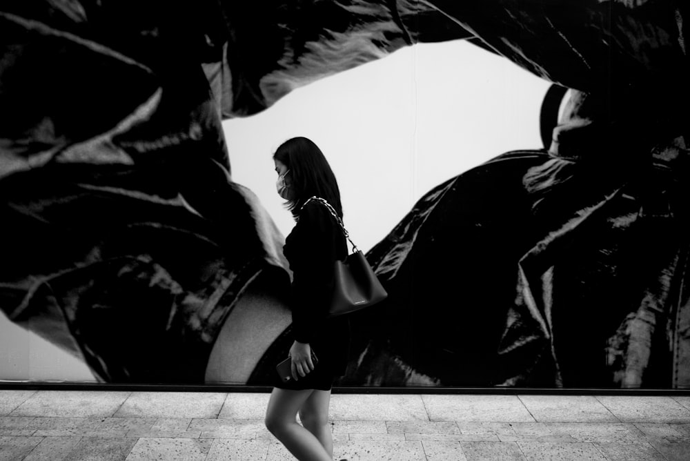 grayscale photo of woman in black coat and black skirt