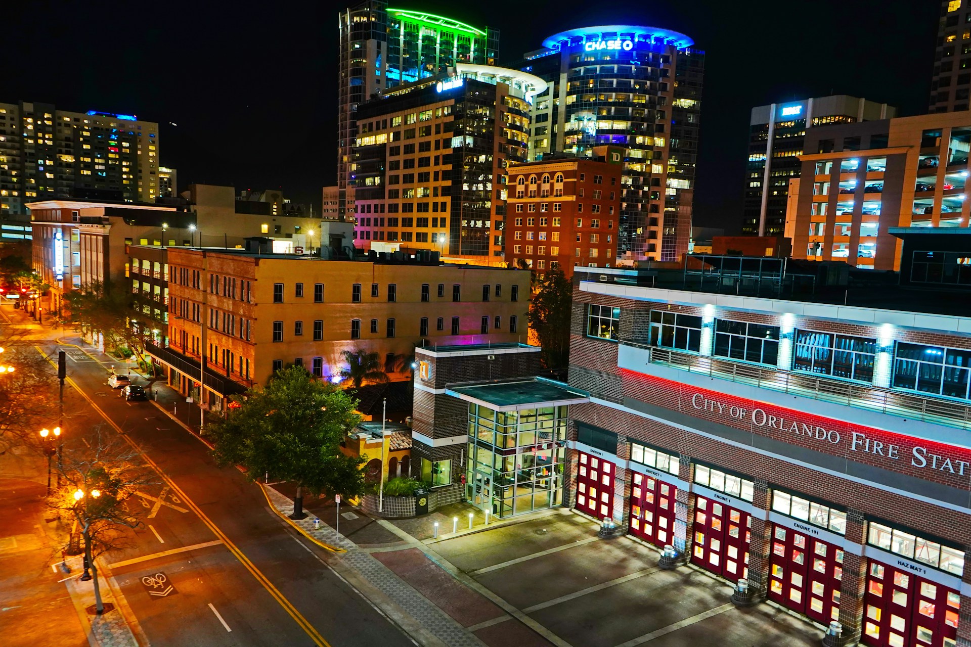 a city street at night with buildings lit up