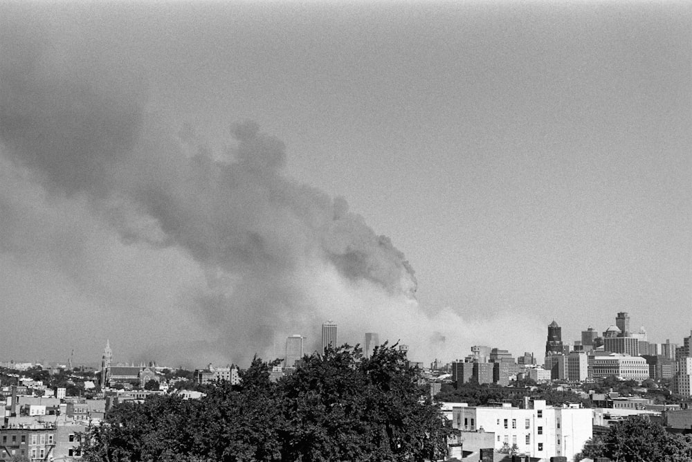 a black and white photo of smoke billowing from a factory