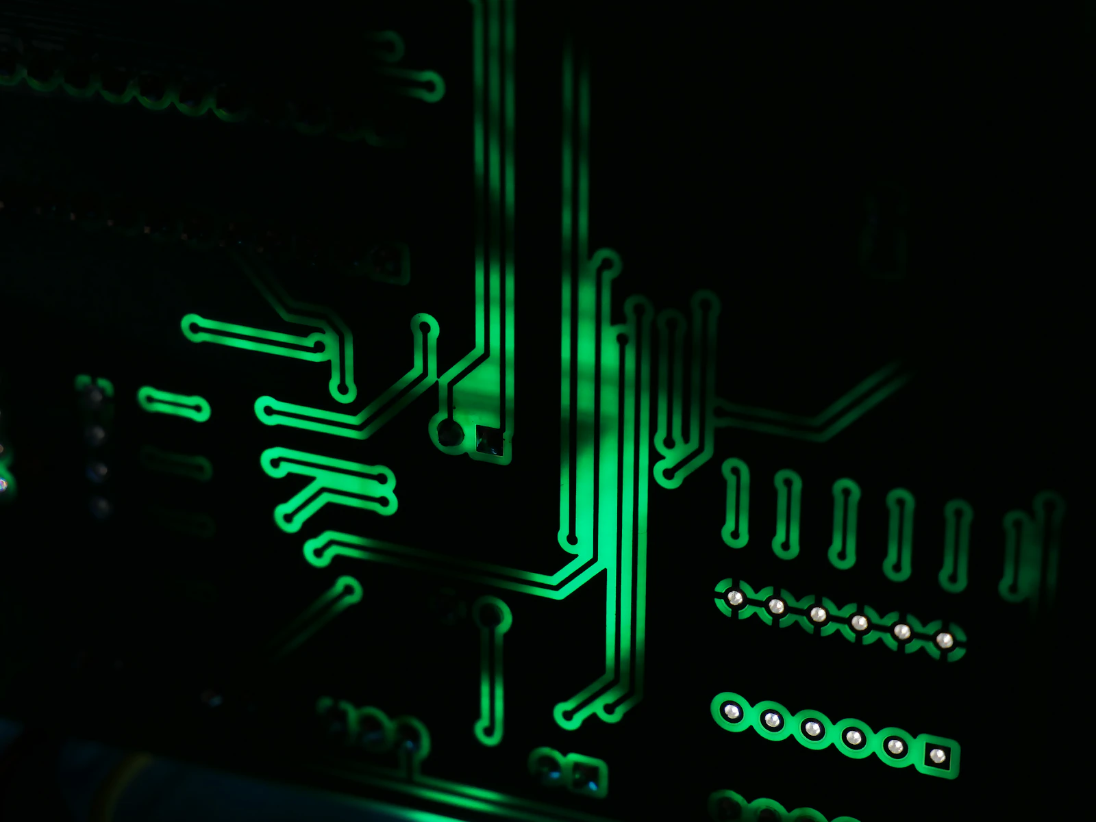 Close-up of illuminated circuit traces on a printed circuit board