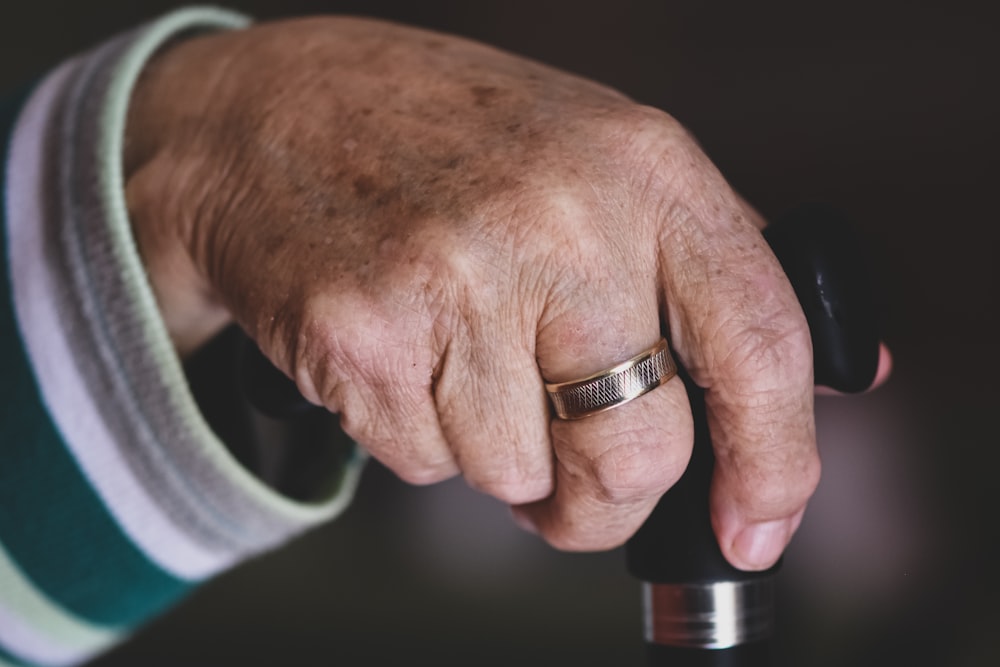 a close up of a person's hand with a ring on it