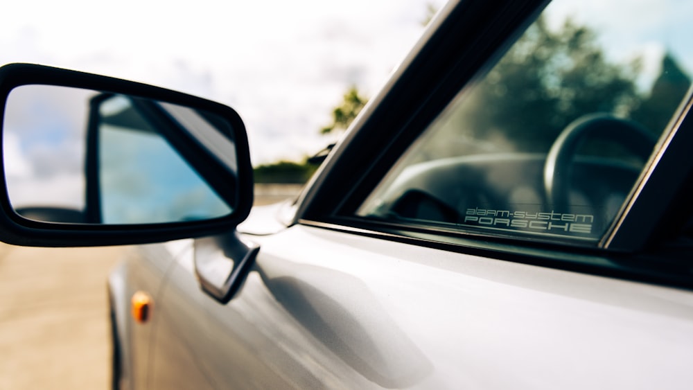 a side view mirror of a car on the side of the road