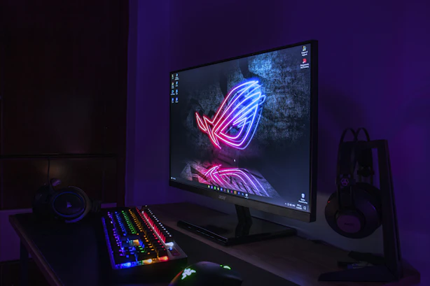 a computer monitor and keyboard lit up in the dark