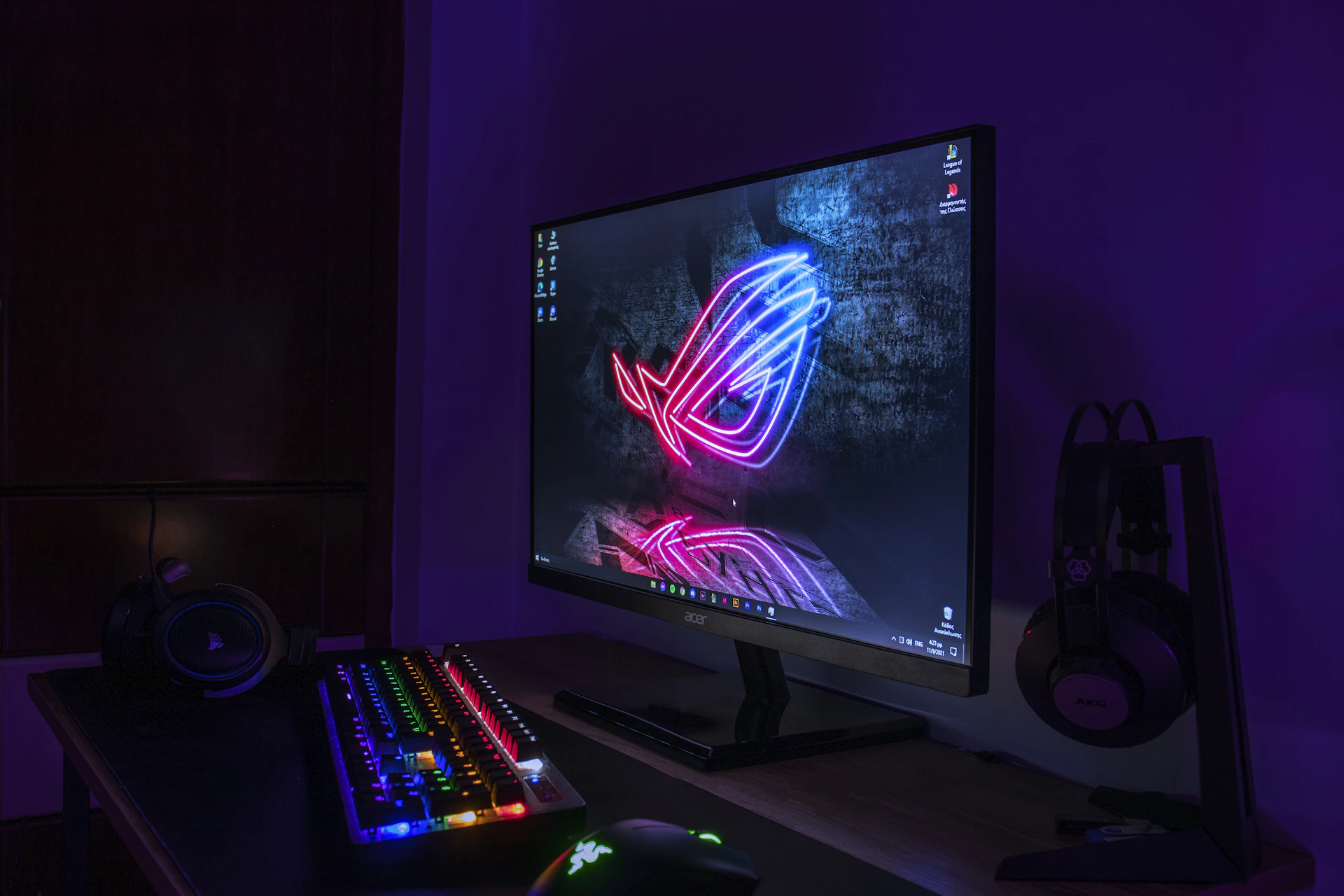 a computer monitor and keyboard lit up in the dark