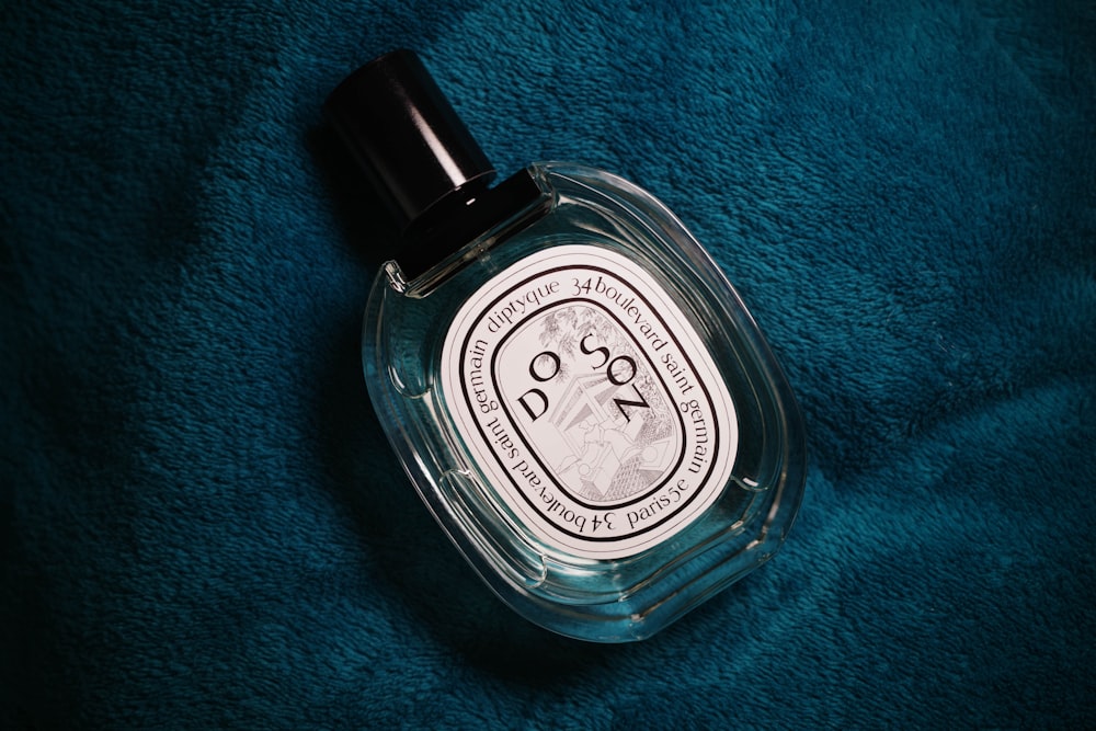 a bottle of cologne sitting on top of a blue blanket