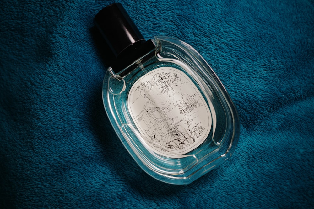 a bottle of perfume sitting on a blue towel