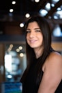 a woman in a black dress smiling at the camera