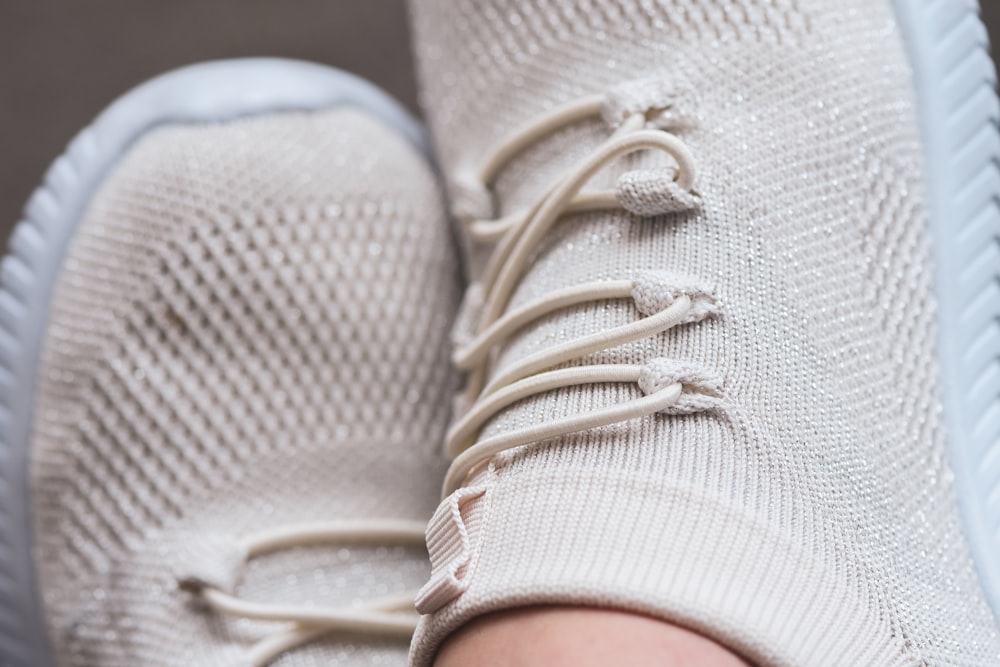 a close up of a person's white sneakers