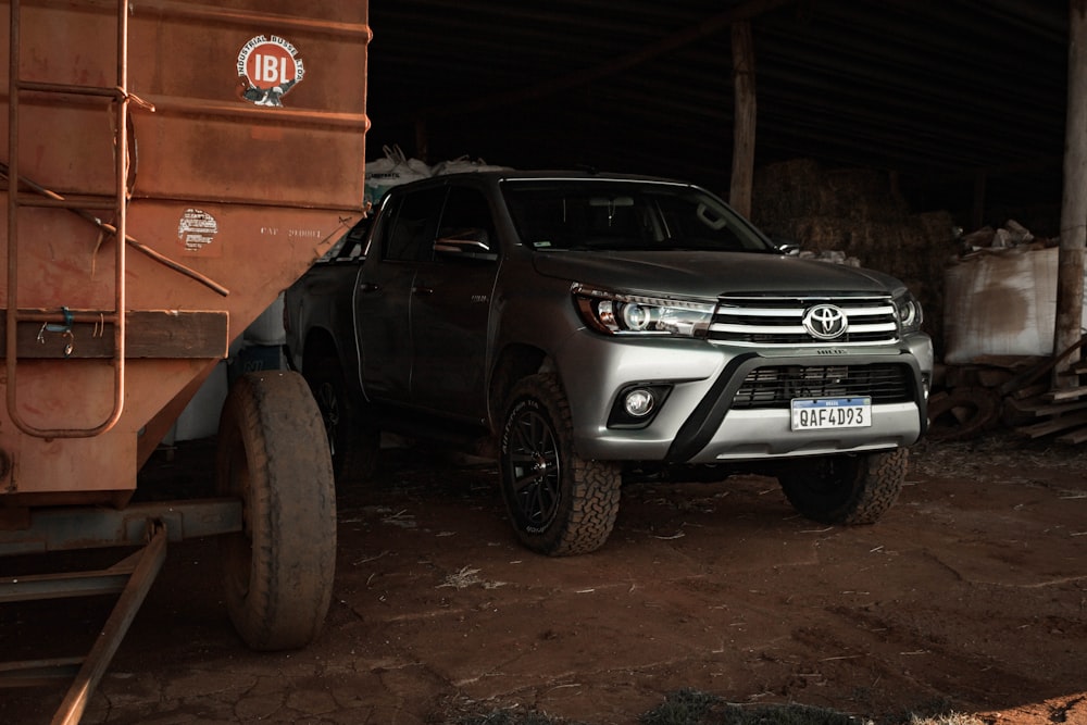 a silver truck parked next to a dump truck