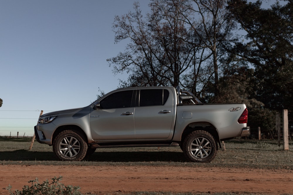 a silver pick up truck parked on a dirt road