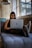 A confident woman using a laptop in a cozy, dimly lit room.