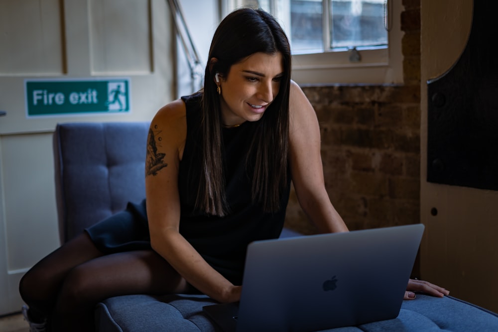 a woman sitting on a couch using a laptop computer