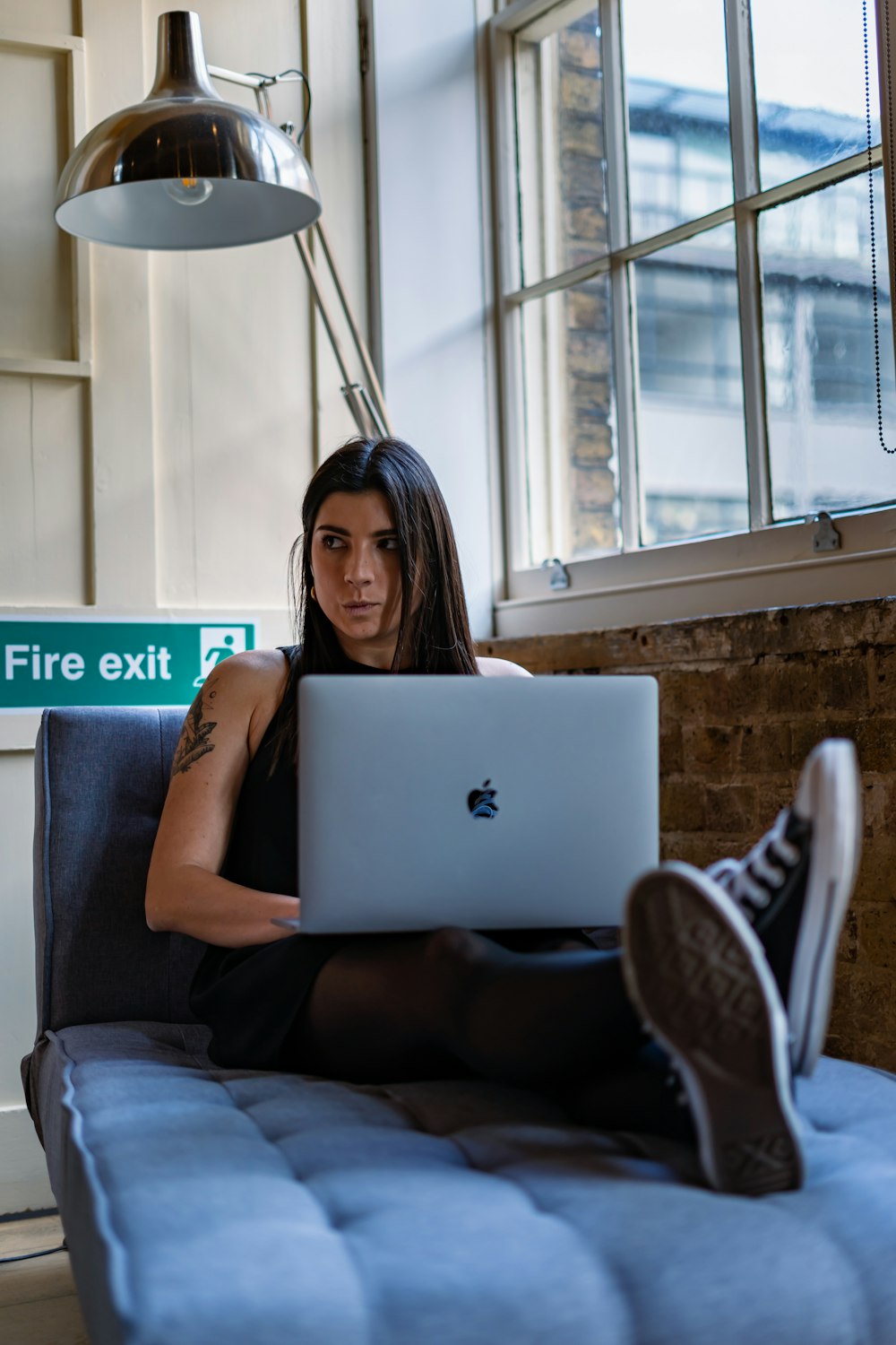 a woman sitting on a couch using a laptop computer