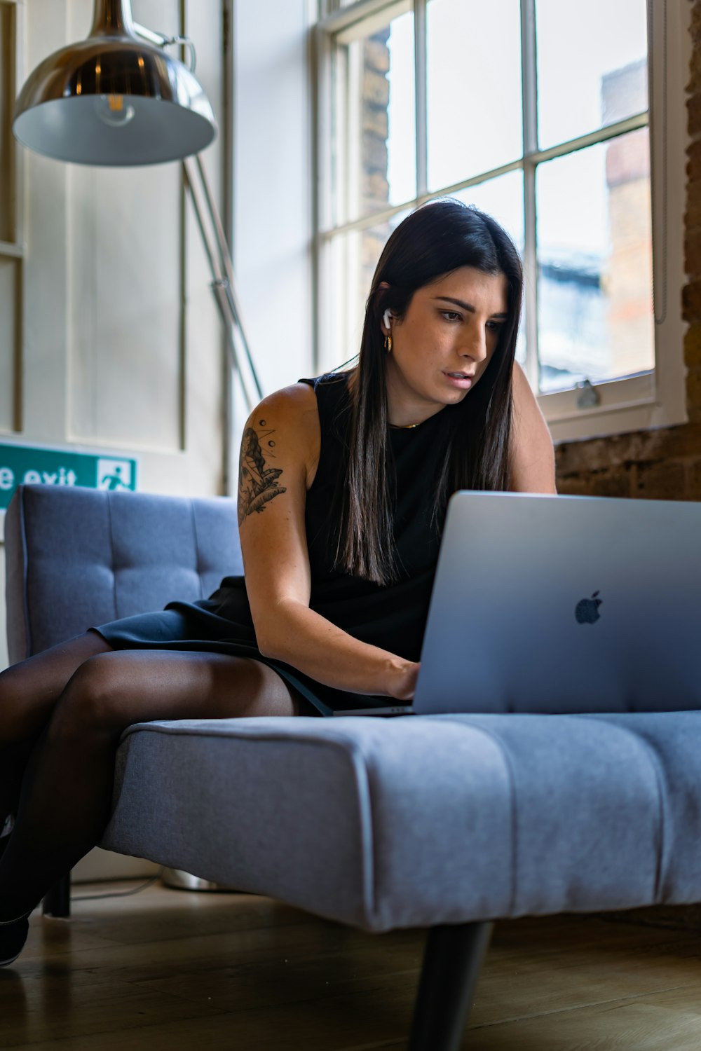 a woman sitting on a couch using a laptop