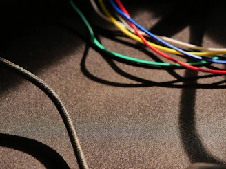Coiled bundles of colorful wires and cables neatly arranged on a deep blue surface