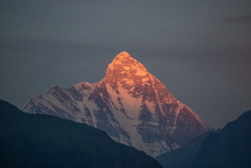 brown and white mountain under gray sky