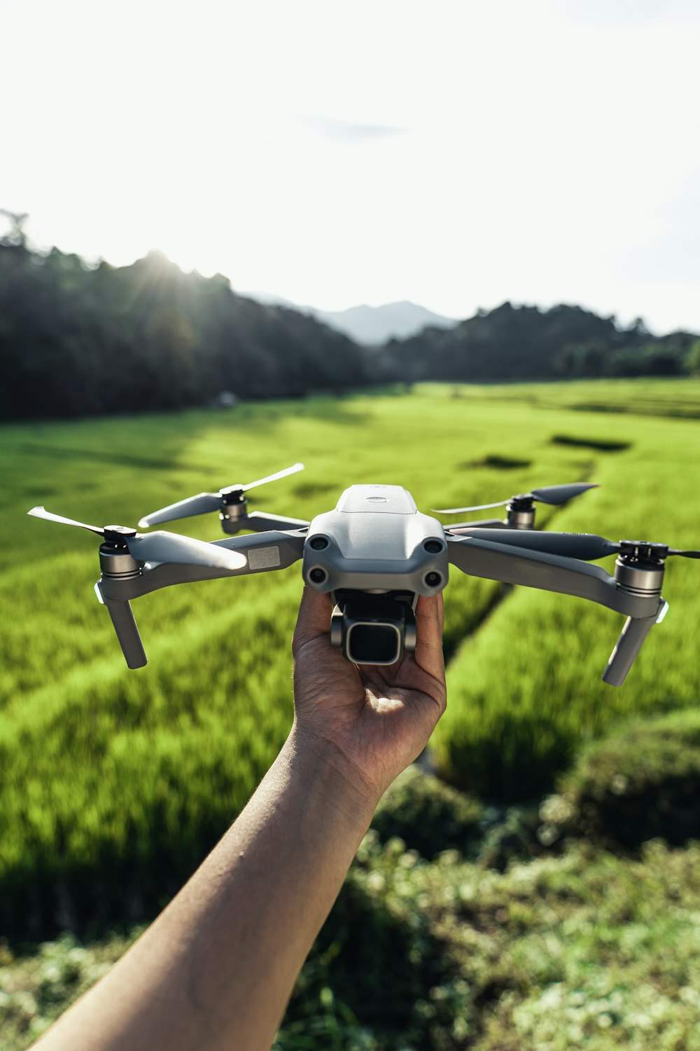 a person holding a small white and black remote controlled flying device