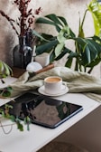 A serene morning scene with a coffee cup and a tablet showing stock updates.