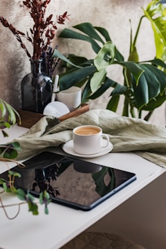 A calm morning scene with a cup of coffee beside a minimalist blog layout on a tablet.