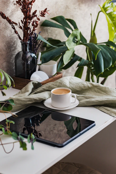 A cozy kitchen scene showing a person checking out groceries on a tablet with a cup of coffee nearby.