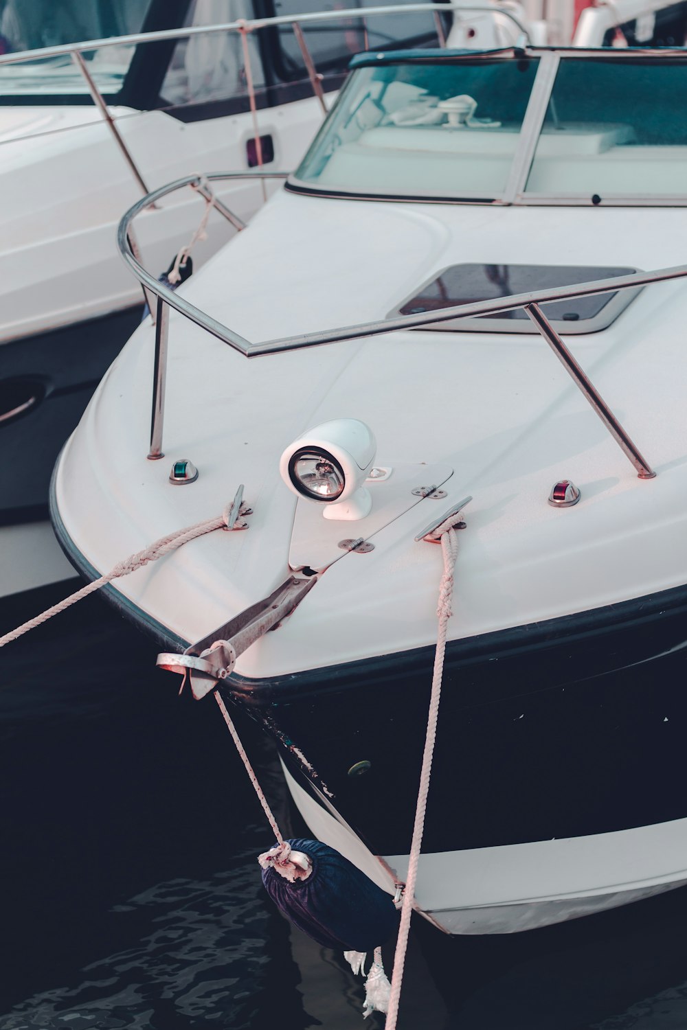 a white and black boat tied to a dock