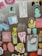 A collection of colorful stickers on a textured surface, featuring various designs including a cat photo with text, a tooth with 'BITE ME' text, artistic portraits, a packet labeled 'Ms. Toof Ache’s Toof Tac,' and several abstract and cartoon-like images.