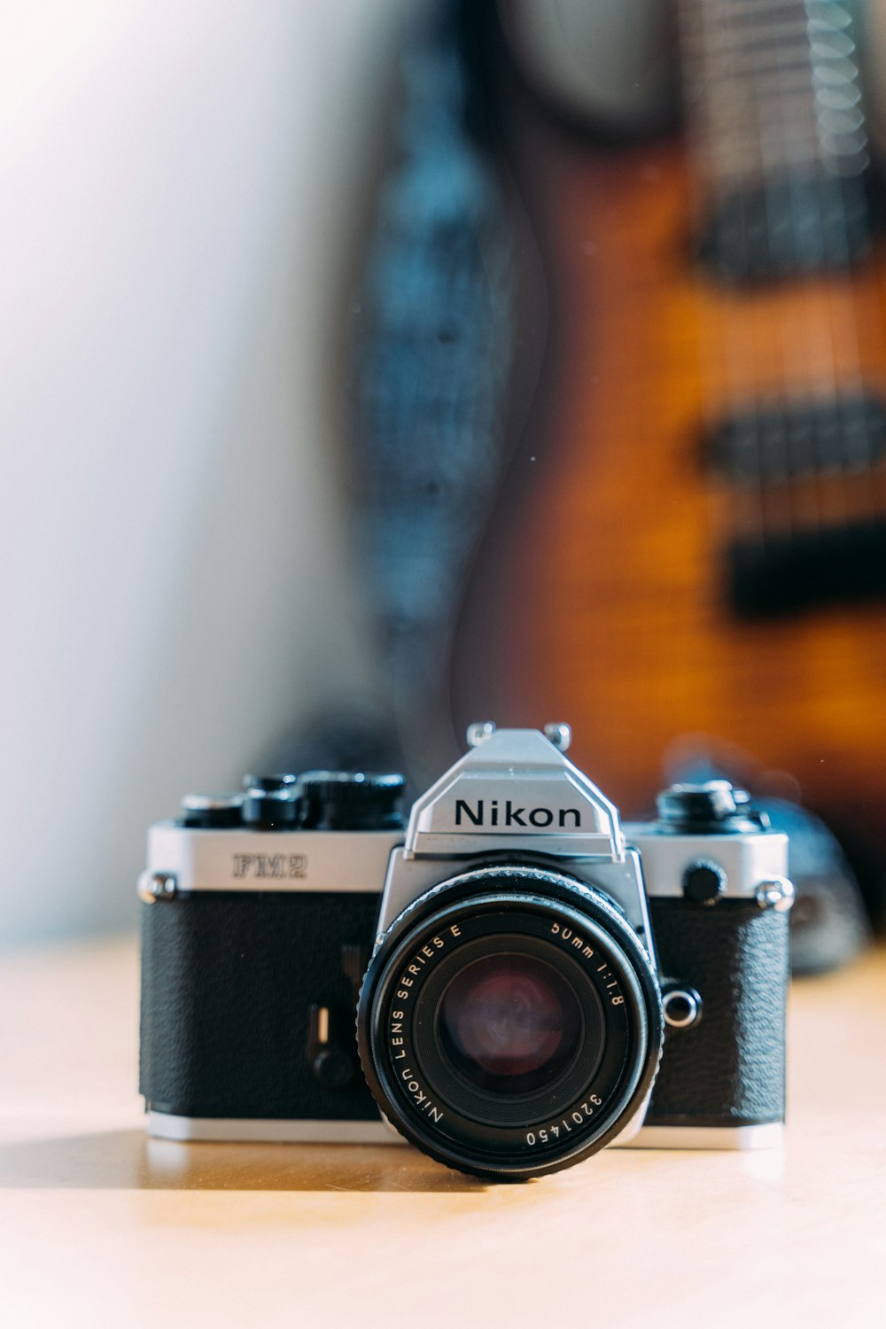 a camera sitting on top of a table next to a guitar